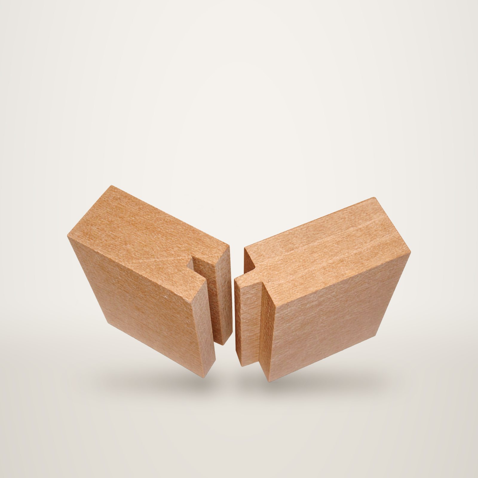 Deux blocs de bois clair présentant chacun une rainure, placés face à face sur un fond noir.